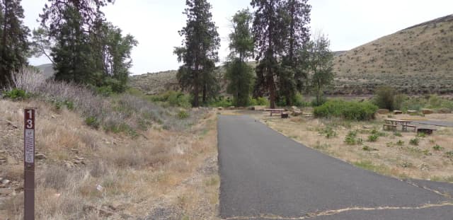 Parking pad, picnic table and fire ring at Big Pines Campsite #13