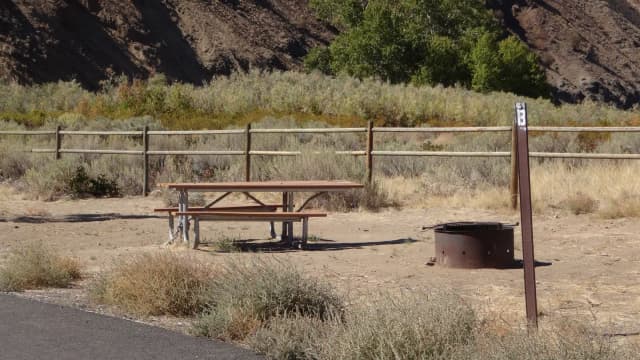 Picnic table, paved trail and fire ring at Big Pines Walk-in Campsite #B