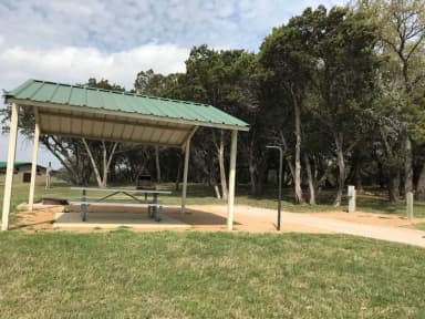 RV site with covered picnic table, grill, fire ring, and restroom/shower facilites nearby