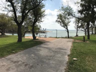 RV site with picnic table, grill, fire ring, and view of Waco Lake