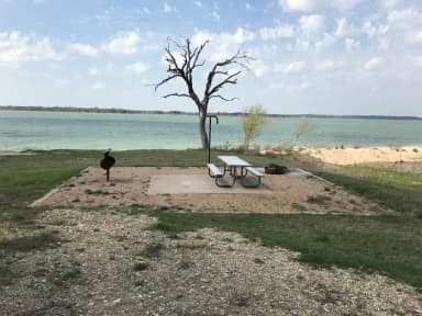 Tent site with picnic table, grill, and fire ring.  Site is located very close to shoreline of Waco Lake
