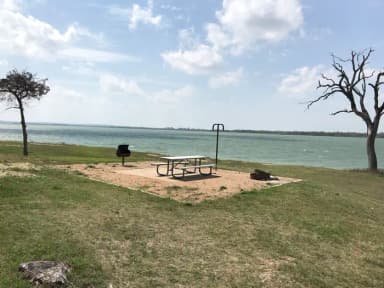 Tent site with picnic table, grill, and fire ring.  Site is located very close to shoreline of Waco Lake
