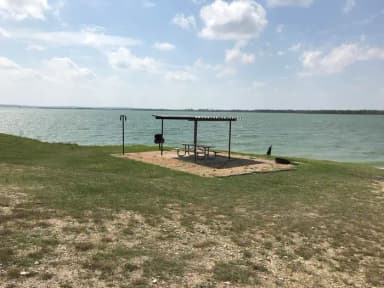 Tent site with picnic table, grill, and fire ring.  Site is located very close to shoreline of Waco Lake