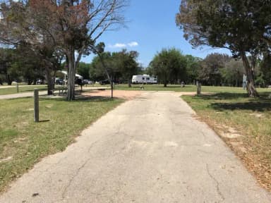 RV site with picnic table, grill, and fire ring.