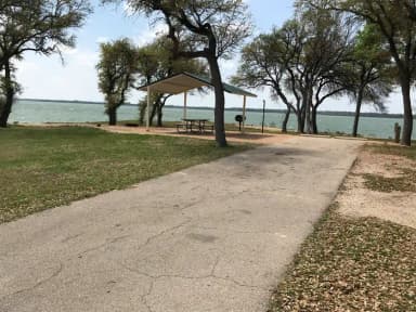 RV site with covered picnic table, grill, and fire ring with great view of Waco Lake