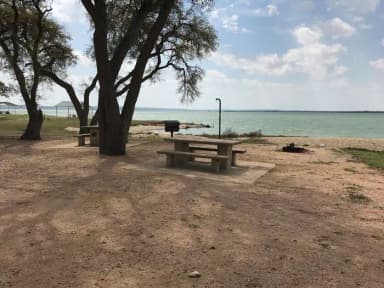 Tent site with picnic table, grill, and fire ring.  Site is located very close to shoreline of Waco Lake