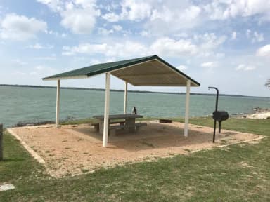 Tent site with covered picnic table, grill, and fire ring.  Site is located very close to shoreline of Waco Lake