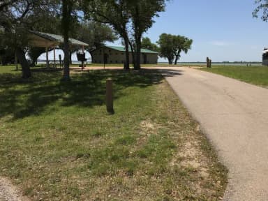 RV site with covered picnic table, grill, fire ring, and restroom/shower facilities nearby