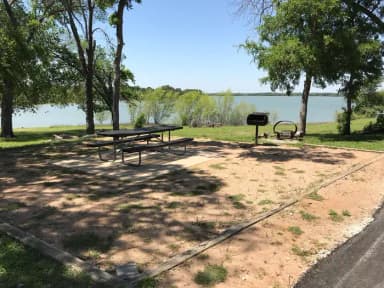 Picnic table, grill, and fire ring at site with great view of Waco Lake