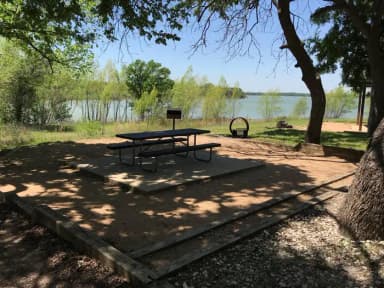 Picnic table, grill, and fire ring at site with great view of Waco Lake