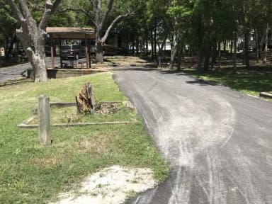 RV site with covered picnic table, grill, and fire ring