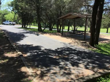RV site with covered picnic table, grill, and fire ring