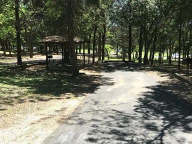 RV site with covered picnic table, grill, and fire ring