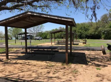Covered picnic table, grill, and fire ring with other sites nearby