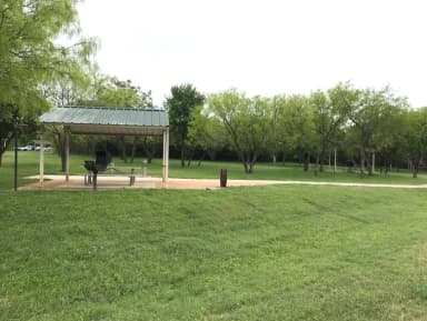 RV site with covered picnic table, grill, and fire ring