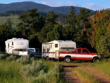 Photo of a trucks and trailers in a campsite area.