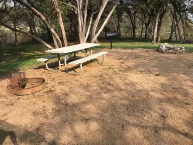 Picnic table, grill, and fire ring at site
