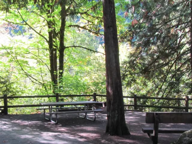 Large camp site with views of the river, sitting bench, picnic table and fire ring