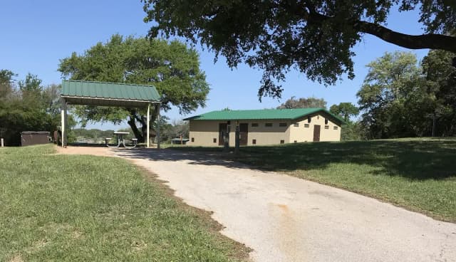 RV site with covered picnic table, grill, fire ring, and restroom/shower facilites nearby