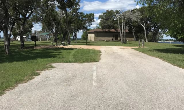 RV site with grill, fire ring, picnic table, and restroom/shower facilities nearby