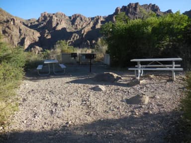 Picnic tables at a campsite with mountains in the background