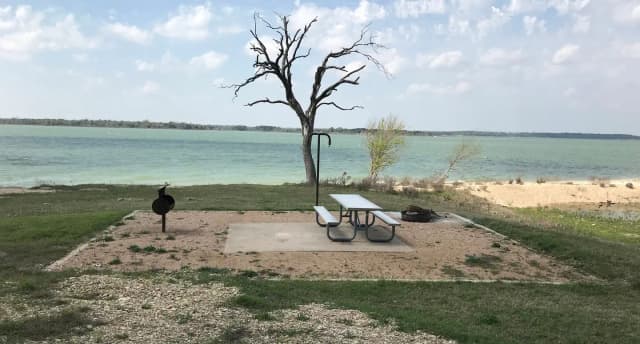 Tent site with picnic table, grill, and fire ring.  Site is located very close to shoreline of Waco Lake