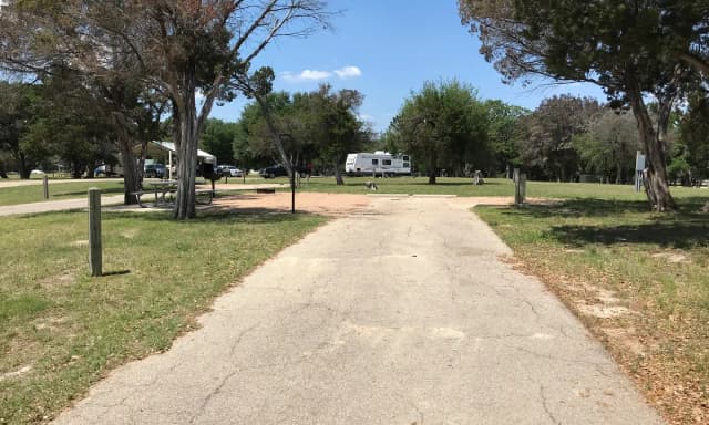 RV site with picnic table, grill, and fire ring.