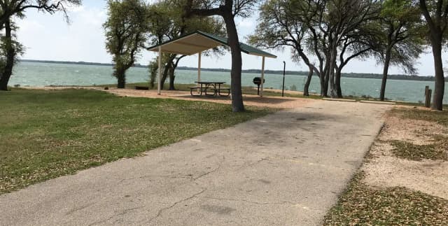 RV site with covered picnic table, grill, and fire ring with great view of Waco Lake