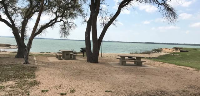 Tent site with picnic table, grill, and fire ring.  Site is located very close to shoreline of Waco Lake