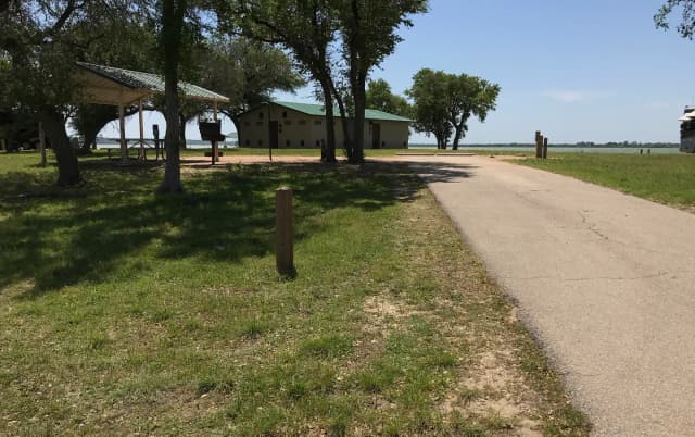 RV site with covered picnic table, grill, fire ring, and restroom/shower facilities nearby