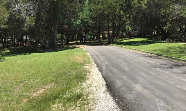 RV site with covered picnic table, grill, and fire ring