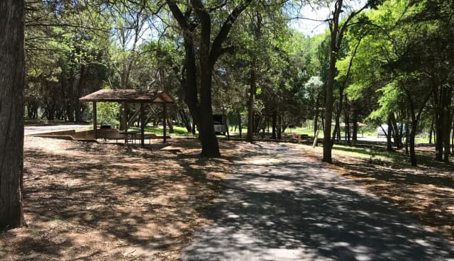 RV site with covered picnic table, grill, and fire ring