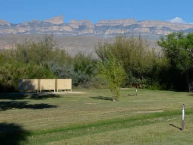 Flat area for tents, with bear boxes at the rear of the site, under the mountains