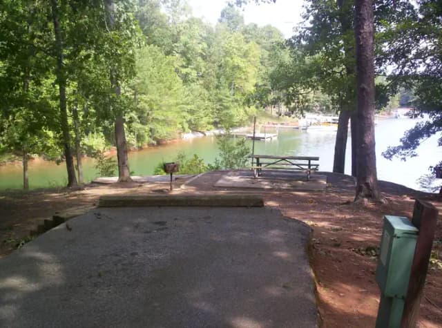 Paved back in spot, picnic table, water view.