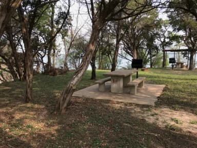 Picnic table and grill at site with Waco Lake in the background