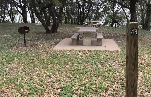 Tent site with picnic table, grill, and Waco Lake in the background