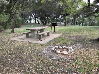 Tent site with picnic table, grill, and Waco Lake in the background