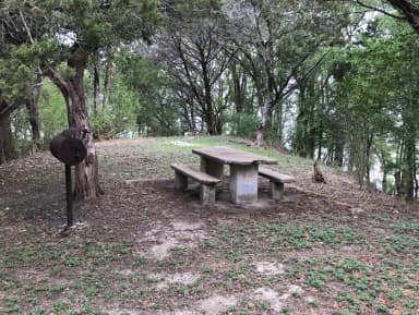 Tent site with picnic table, grill, and Waco Lake in the background