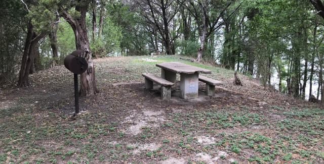 Tent site with picnic table, grill, and Waco Lake in the background