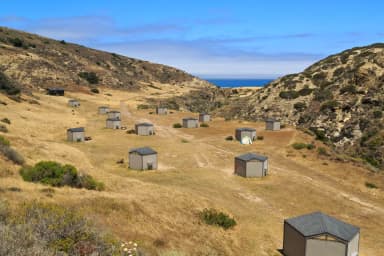 Eight foot tall wind shelters on a dry, grassy terrace overlooking the ocean., filed by the agency against 15 campsites at Santa Rosa Island