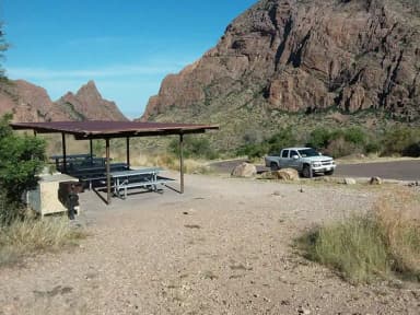 Shade structure and gathering area with parking space and Window in the background