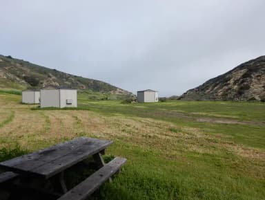 View of wide canyon with picnic table and green grass in foreground.