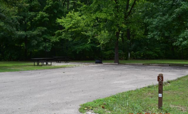 Campsite 3 show double wide parking spur, picnic tables, lantern post and fire ring