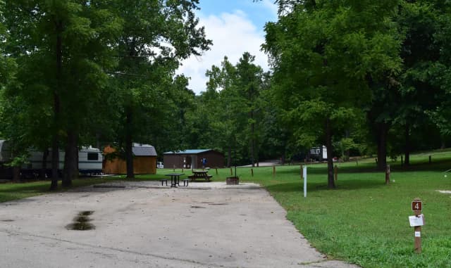 Double Campsite 4 showing double wide parking, picnic tables, lantern post, electric hookup and fire ring