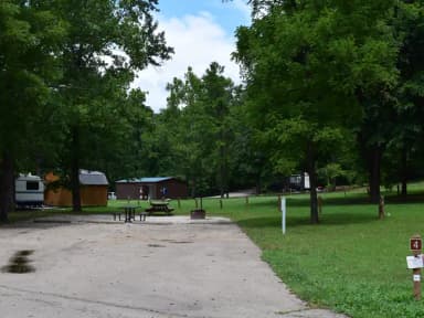 Double Campsite 4 showing double wide parking, picnic tables, lantern post, electric hookup and fire ring