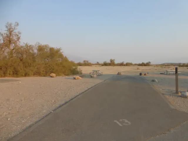 Furnace Creek Campground Standard Non-electric Site #13 with picnic table, fire ring and paved parking pad.
