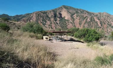 Shade structure and gathering area amidst the green and brown mountains