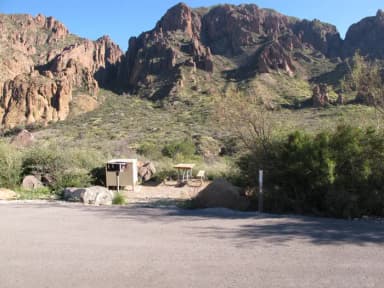 Flat, rocky site with mountain views in background