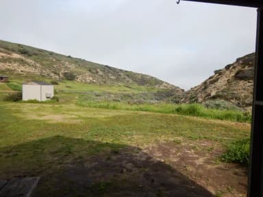 View of wide canyon with picnic table and green grass in foreground.