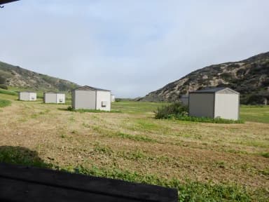 View of wide canyon with picnic table and green grass in foreground.